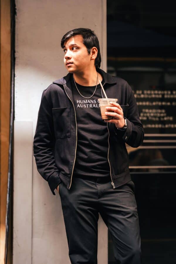 A chic image of a man wearing the Humans of Australia Black Jumper, perfect for all occasions