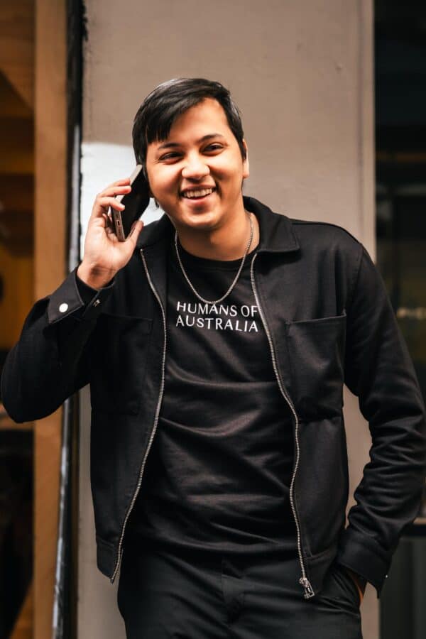 A confident man wearing the stylish and comfortable Humans of Australia Black Jumper.