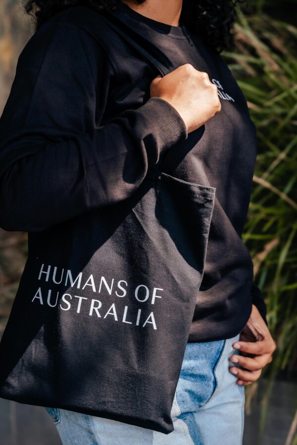 A woman walking gracefully while carrying the Humans of Australia Tote Bag.