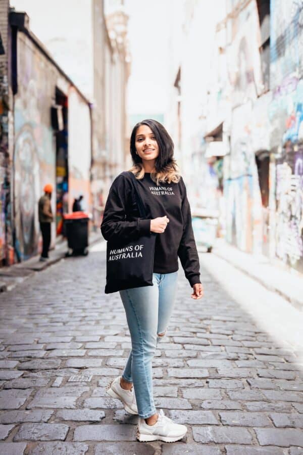 A woman walking gracefully while carrying the Humans of Australia Tote Bag.