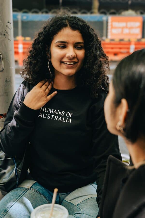 Two women sharing a moment in the fashionable and cozy Humans of Australia Black Jumpers